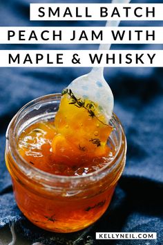 maple peach whiskey jam in a glass jar with a spoon sticking out of the top