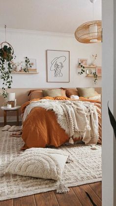 a bedroom with white walls and wooden flooring, an orange blanket on the bed