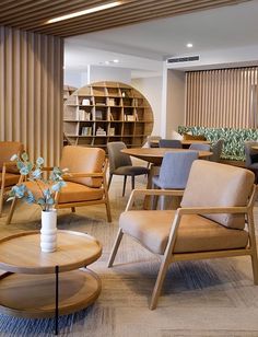 a room filled with lots of furniture and bookshelves next to a wall covered in wooden slats