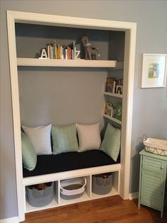 a white book shelf filled with lots of books next to a baby's crib