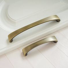 two brass handles on a white counter top