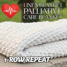 a white blanket sitting on top of a stone wall next to a red heart with the words linen blanket pallative care blanket