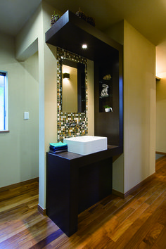 a bathroom with a sink and mirror in it's center wall, along with hardwood floors