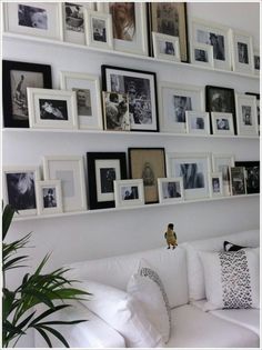 a white couch sitting in front of a wall with pictures on it's sides