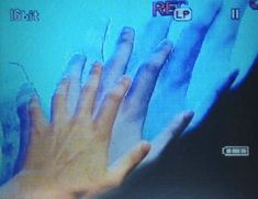 someone is holding their hand out to touch the screen on tv or in front of them