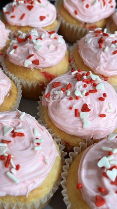 many cupcakes with pink frosting and sprinkles