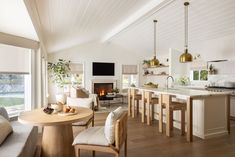 a kitchen and living room are separated by an open floor plan, with white walls