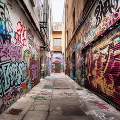 an alley with graffiti all over the walls