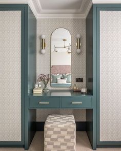 a dressing table with a mirror and stool in a room that is painted teal