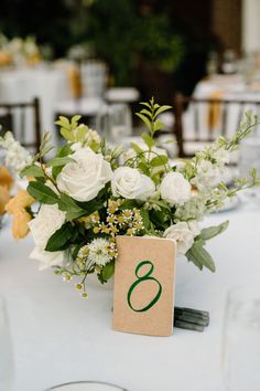 Image shows a white, yellow and green floral centerpiece next to a table number 8, in the wedding reception space of the New England Botanic Garden at Tower Hill. Green Wedding Centerpieces, Green Wedding