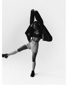 black and white photograph of a woman dancing with her legs spread out in the air