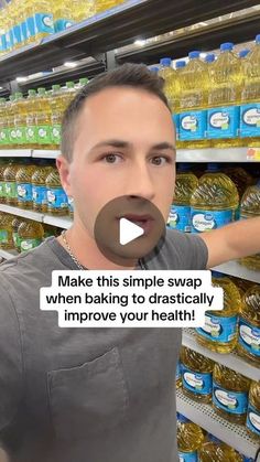 a man in grey shirt standing next to shelves filled with water