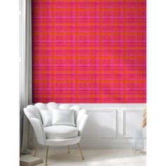 an orange and pink plaid wallpaper in a living room with white chair, window sill