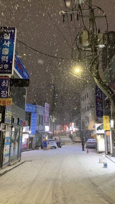 a snowy street with cars parked on it