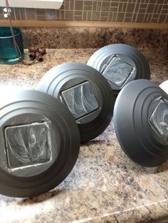 three gray bowls sitting on top of a counter