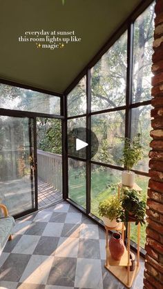 the inside of a house with large windows and lots of plants on the outside wall