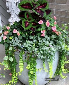 a planter filled with lots of green and pink flowers