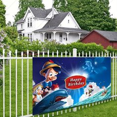 a happy birthday banner on a fence in front of a house