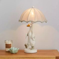 a ducky lamp on a table next to a candle