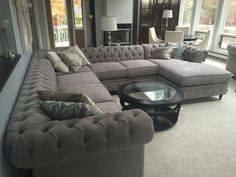 a living room filled with lots of furniture in it's centerpiece and large windows