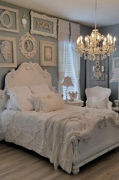 a white bed sitting in a bedroom under a chandelier