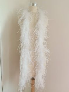 a white feather vest hanging on a wall