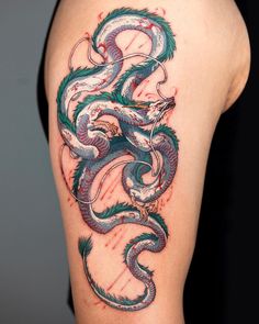 a dragon tattoo on the back of a woman's left shoulder and upper arm