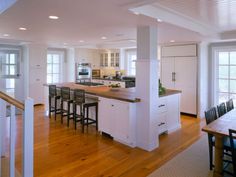 an image of a kitchen with white cabinets and wood flooring in the middle of it