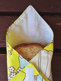 a loaf of bread sitting inside of a bag on top of a wooden table next to a piece of cloth