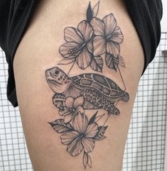 a woman's thigh with a turtle and flowers on it