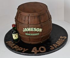 a birthday cake made to look like a barrel with a bottle of jameson on top