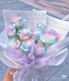 a person holding a bouquet of pink and blue roses