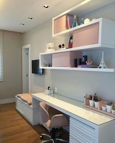 a white desk and chair in a room with wooden flooring, built - in bookshelves and shelves on the wall