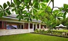 the house is surrounded by lush green grass