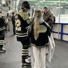 two hockey players are talking to each other in the locker room at an ice rink