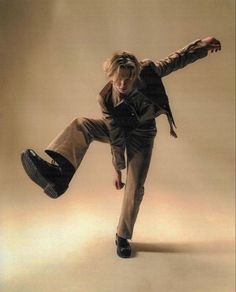 a young man doing a trick on a skateboard in the air with his legs spread out