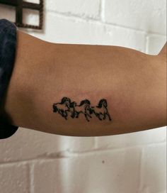 a person's arm with three horses drawn on it and one horse in the middle