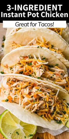 three shredded chicken tacos on a cutting board with lime wedges