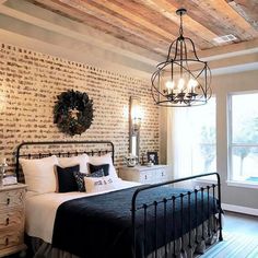 a bed room with a neatly made bed and a chandelier hanging from the ceiling