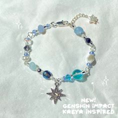 a bracelet with beads and charms is shown on a white sheet that says, new genshin impact key - insured