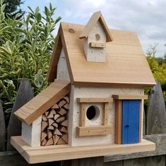 a wooden bird house with a blue door and window