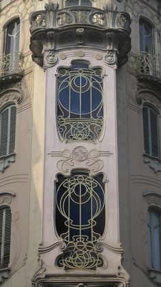 an ornate window on the side of a building with iron bars and balconies