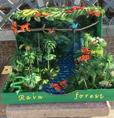 a green box filled with lots of different types of plants and animals on top of it