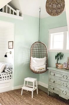 a bedroom with a bed, dresser and hanging chair