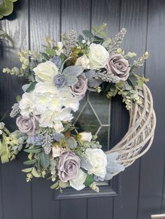 a wreath with flowers and greenery hanging on the front door for an elegant look