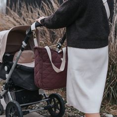 a woman pushing a stroller with a baby in it