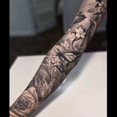 a man's arm with flowers and a butterfly on it