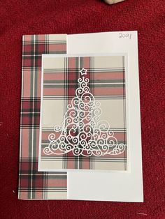 a card with a christmas tree cut out on it next to a pair of scissors