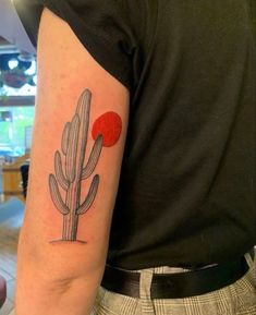 a man's arm with a cactus tattoo on the left side of his arm