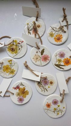 several plates with flowers on them and tags attached to them